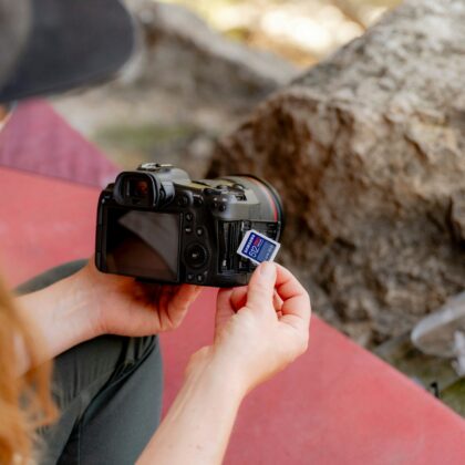 A woman taking a picture of a rock with a camera